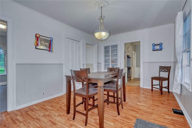2360 Harris Rd, Palmyra, NY 14522 - dining area with light wood-style flooring, wainscoting, a decorative wall, and ornamental molding