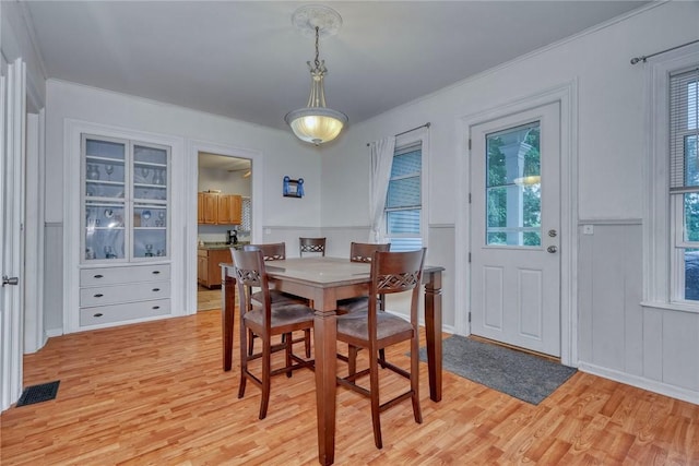 2360 Harris Rd, Palmyra, NY 14522 - dining room with light wood-style floors, plenty of natural light, a decorative wall, ornamental molding, and wainscoting