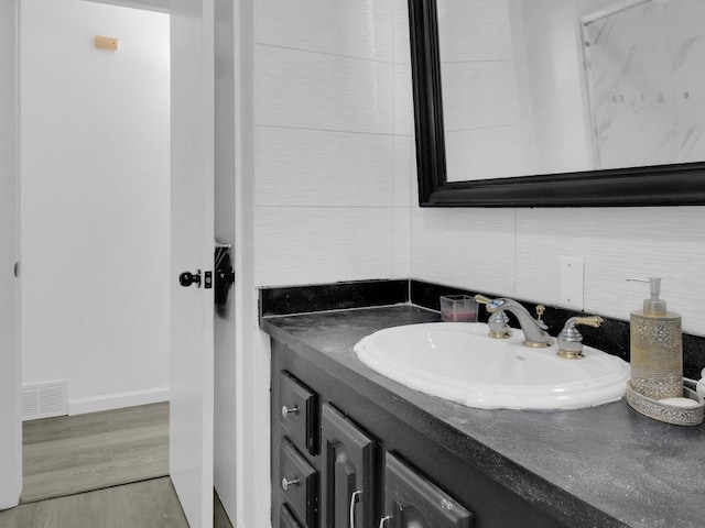 449 Pinnacle Rd, Henrietta, NY 14623 - bathroom featuring backsplash, vanity, and wood finished floors