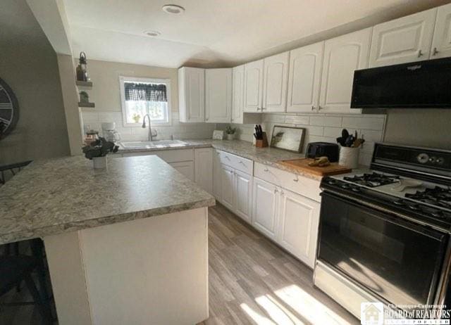 3 Mapleview Ave, Busti, NY 14750 - kitchen featuring gas range oven, light wood finished floors, tasteful backsplash, and white cabinets