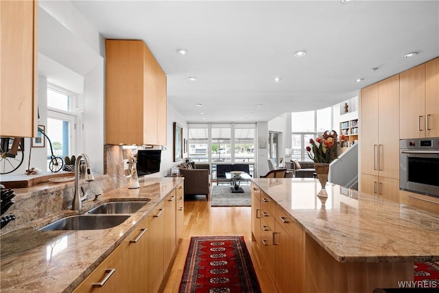 176 Rivermist Dr, Buffalo, NY 14202 - kitchen with stainless steel oven, light wood finished floors, light stone countertops, open floor plan, and recessed lighting