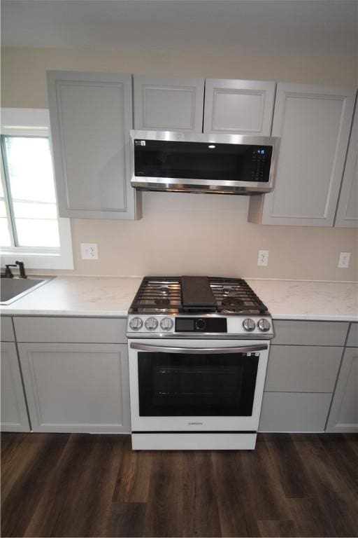 38 Spring St, Sweden, NY 14420 - kitchen with appliances with stainless steel finishes, dark wood finished floors, and light stone countertops