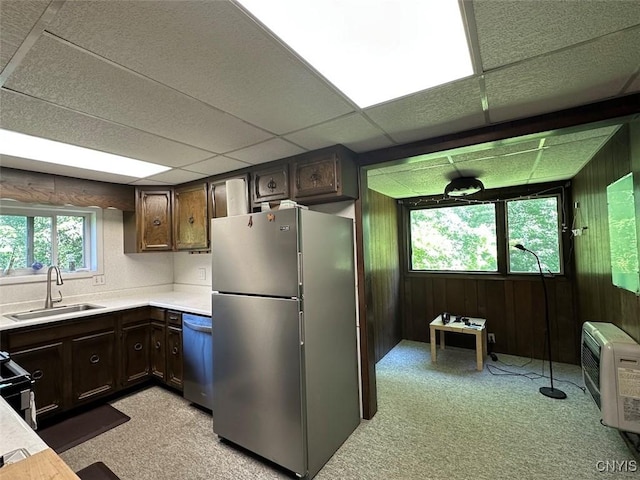 5249 State Route 21, Alfred, NY 14803 - kitchen featuring stainless steel appliances, dark brown cabinetry, light countertops, wooden walls, and light colored carpet