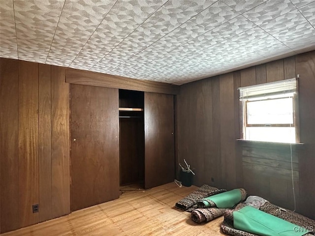 5249 State Route 21, Alfred, NY 14803 - unfurnished bedroom with wood walls, light wood-type flooring, and a closet