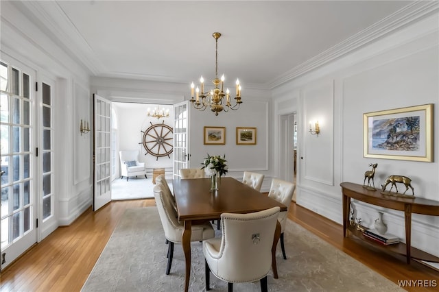 6862 Lake Shore Rd, Evans, NY 14047 - dining space with a chandelier, ornamental molding, a decorative wall, and wood finished floors