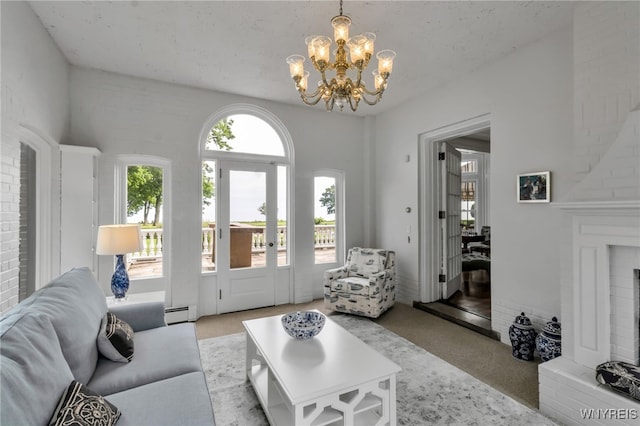 6862 Lake Shore Rd, Evans, NY 14047 - carpeted living area featuring a chandelier, baseboard heating, and a brick fireplace