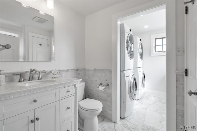 6862 Lake Shore Rd, Evans, NY 14047 - bathroom with stacked washer / dryer, vanity, marble finish flooring, wainscoting, and tile walls