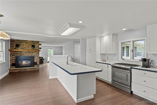 9015 Donahue Rd, Batavia, NY 14020 - kitchen featuring stainless steel gas stove, open floor plan, dark wood-style flooring, light countertops, and white cabinetry