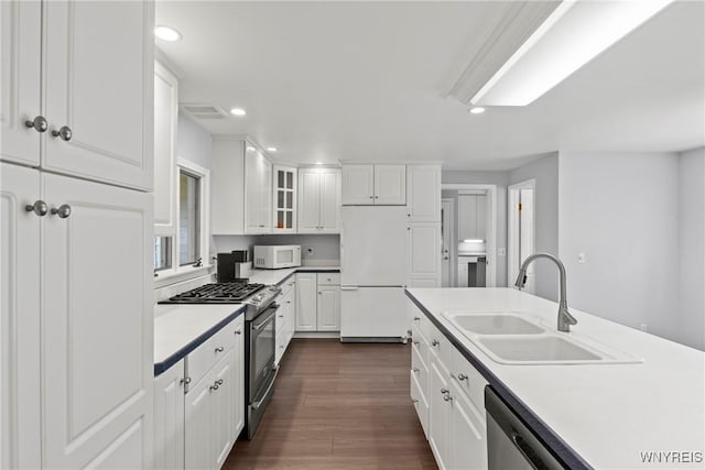 9015 Donahue Rd, Batavia, NY 14020 - kitchen featuring stainless steel appliances, recessed lighting, white cabinetry, dark wood-type flooring, and glass insert cabinets