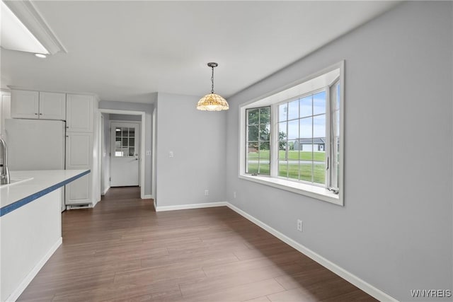 9015 Donahue Rd, Batavia, NY 14020 - unfurnished dining area featuring baseboards and dark wood-style flooring