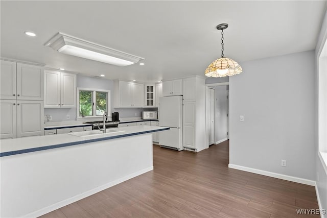 9015 Donahue Rd, Batavia, NY 14020 - kitchen with freestanding refrigerator, glass insert cabinets, white cabinets, recessed lighting, and hanging light fixtures