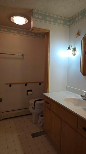 8198 Rte 46, Keating Town, PA 16749 - half bath featuring a baseboard radiator, vanity, and tile patterned floors