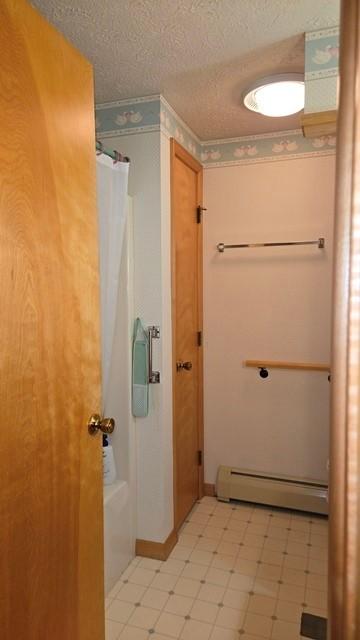 8198 Rte 46, Keating Town, PA 16749 - full bath featuring baseboard heating, a textured ceiling, a shower with curtain, and tile patterned floors