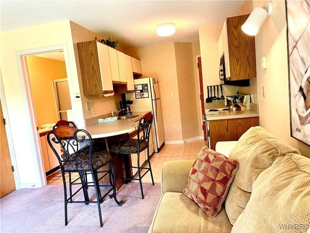 G103 Snowpine Vlg, Great Valley, NY 14741 - kitchen with a breakfast bar, light countertops, white appliances, and light carpet
