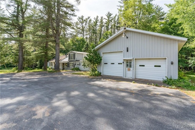 7259 Number Four Rd, Watson, NY 13367 - view of side of home featuring a garage, view of wooded area, and board and batten siding