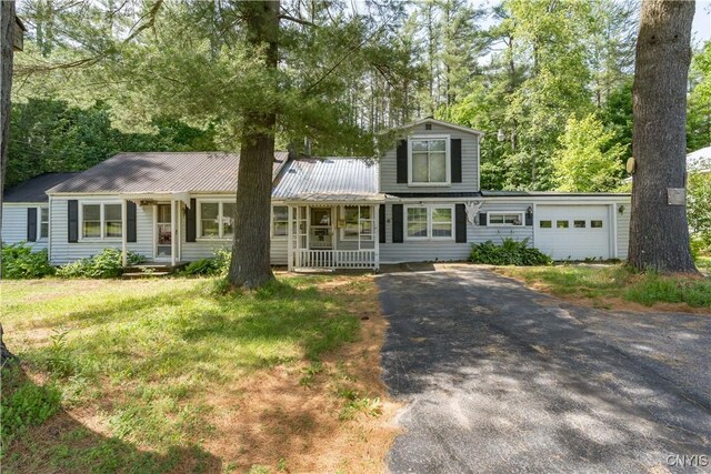 7259 Number Four Rd, Watson, NY 13367 - view of front of house featuring asphalt driveway, an attached garage, a metal roof, and a front lawn