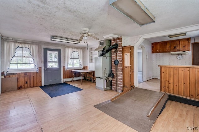 7259 Number Four Rd, Watson, NY 13367 - foyer entrance featuring a baseboard heating unit, light wood-type flooring, a textured ceiling, a ceiling fan, and arched walkways