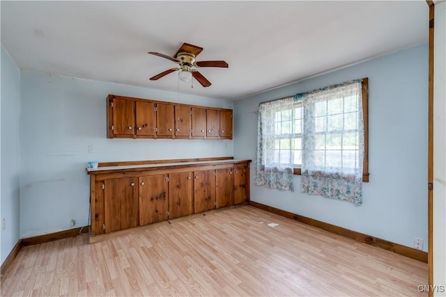 7259 Number Four Rd, Watson, NY 13367 - kitchen featuring brown cabinetry, light wood-type flooring, ceiling fan, and light countertops
