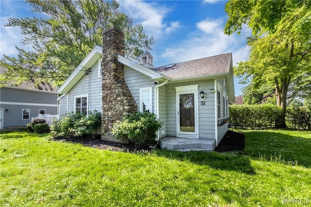 52 Harbor St, Wilson, NY 14172 - rear view of house with a chimney, a lawn, and a shingled roof