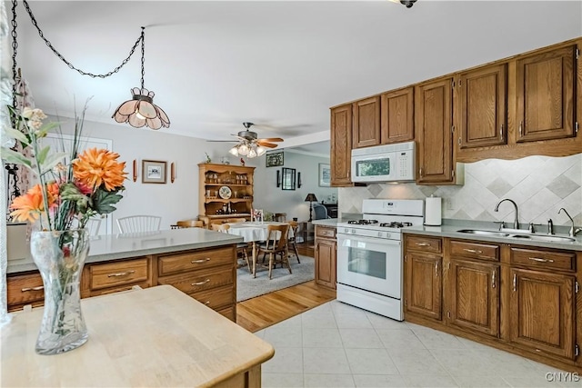 16 Vine Cir, Whitestown, NY 13492 - kitchen with white appliances, brown cabinets, decorative backsplash, and ceiling fan