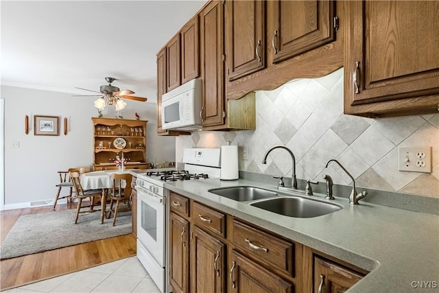 16 Vine Cir, Whitestown, NY 13492 - kitchen with white appliances, a ceiling fan, brown cabinets, and backsplash