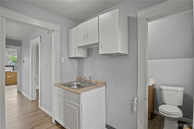 1810 Niagara St, Niagara Falls, NY 14303 - kitchen featuring light wood-style floors, white cabinets, light countertops, and a textured ceiling