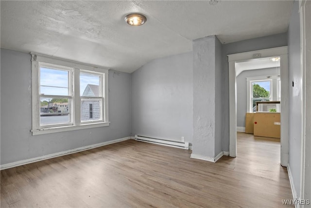 1810 Niagara St, Niagara Falls, NY 14303 - spare room with baseboard heating, wood finished floors, a textured ceiling, and vaulted ceiling