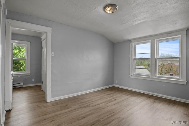 1810 Niagara St, Niagara Falls, NY 14303 - unfurnished room featuring a baseboard radiator, vaulted ceiling, wood finished floors, and a textured ceiling
