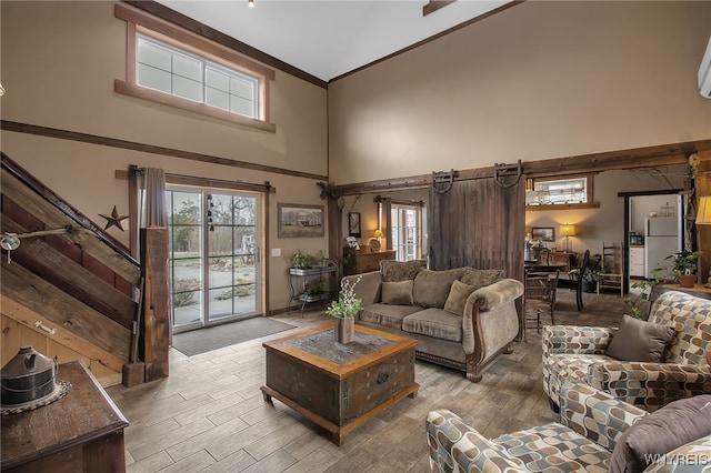 2244 Lockport Olcott Rd, Newfane, NY 14108 - living room with a towering ceiling, wood finished floors, ornamental molding, and plenty of natural light