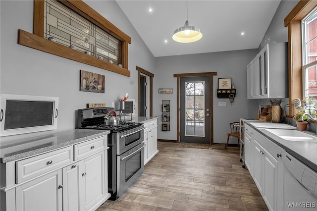 2244 Lockport Olcott Rd, Newfane, NY 14108 - kitchen featuring range with two ovens, white cabinets, light wood-style flooring, dishwasher, and hanging light fixtures