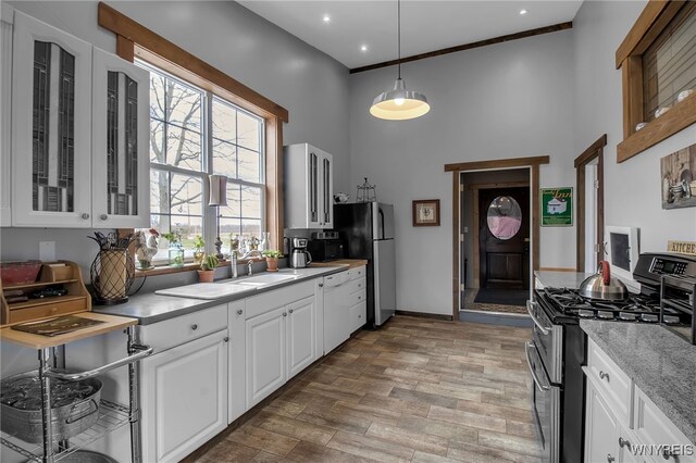 2244 Lockport Olcott Rd, Newfane, NY 14108 - kitchen with stainless steel appliances, a high ceiling, light wood-style floors, white cabinetry, and glass insert cabinets