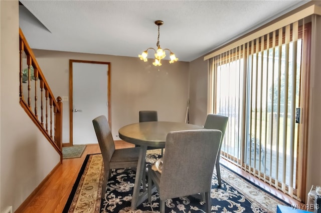 6192 Thornwood Dr, Boston, NY 14075 - dining area with wood finished floors, stairs, and a chandelier