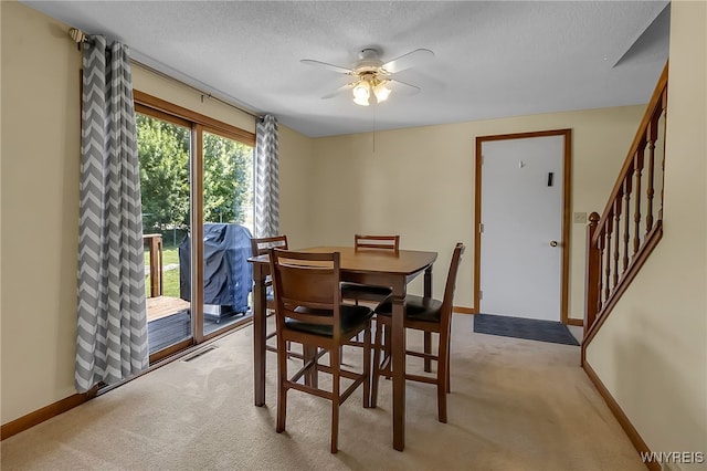 6192 Thornwood Dr, Boston, NY 14075 - dining room with light colored carpet, a ceiling fan, a textured ceiling, and stairway