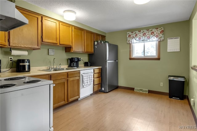 6192 Thornwood Dr, Boston, NY 14075 - kitchen with range hood, white appliances, light countertops, light wood-style floors, and brown cabinetry