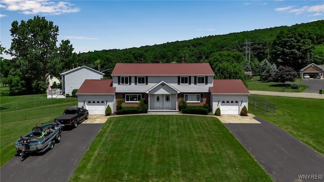 6192 Thornwood Dr, Boston, NY 14075 - colonial house featuring driveway, a garage, and a view of trees