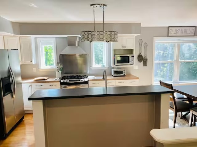 1565 Tupper Hill Rd, Franklin, NY 13775 - kitchen featuring stainless steel appliances, custom exhaust hood, white cabinets, light wood-style floors, and a kitchen island