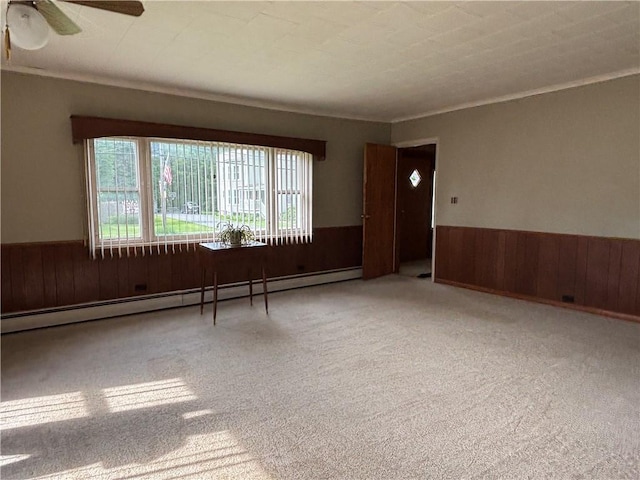 21 Main St, Maryland, NY 12155 - spare room featuring wooden walls, wainscoting, baseboard heating, carpet flooring, and crown molding