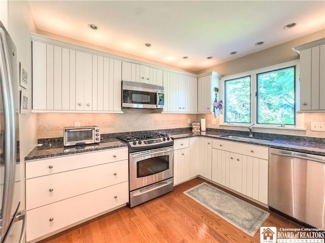 20 Elm Ln Unit E5, Chautauqua, NY 14722 - kitchen featuring appliances with stainless steel finishes, light wood finished floors, dark stone countertops, decorative backsplash, and recessed lighting