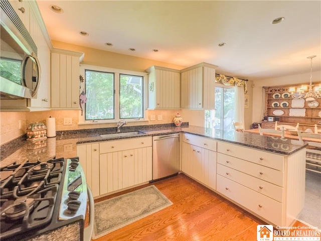 20 Elm Ln Unit E5, Chautauqua, NY 14722 - kitchen with appliances with stainless steel finishes, a peninsula, light wood finished floors, dark stone counters, and pendant lighting