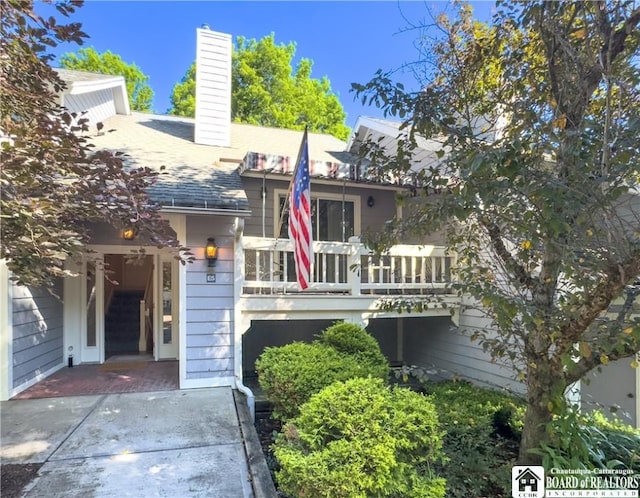 20 Elm Ln Unit E5, Chautauqua, NY 14722 - view of front of home featuring a balcony, a chimney, and a shingled roof