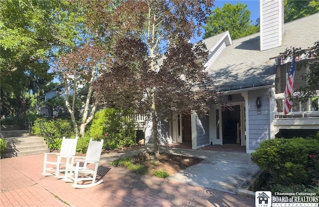 20 Elm Ln Unit E5, Chautauqua, NY 14722 - exterior space featuring roof with shingles, a chimney, and stairway