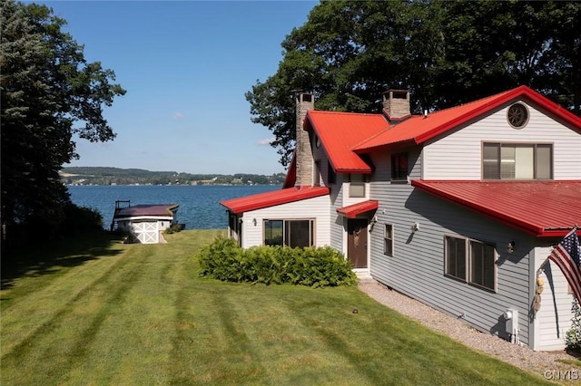 2761 E Lake Rd, Skaneateles, NY 13152 - back of property with a chimney, a yard, a metal roof, and a water view