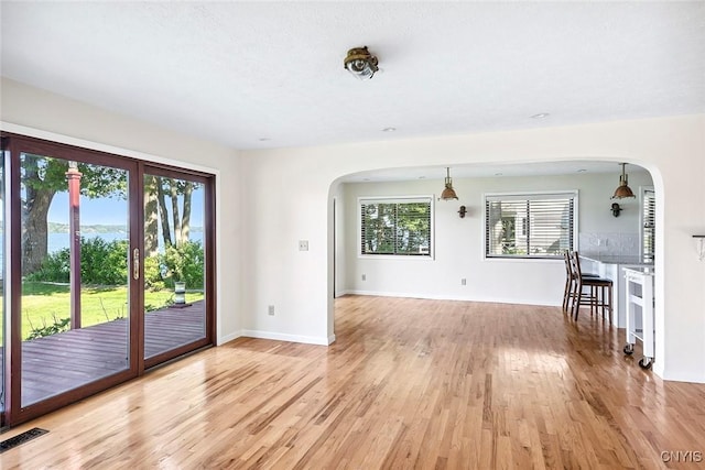 2761 E Lake Rd, Skaneateles, NY 13152 - unfurnished living room featuring arched walkways and light wood finished floors