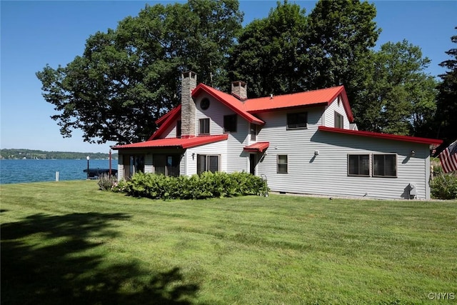 2761 E Lake Rd, Skaneateles, NY 13152 - back of property featuring a chimney, a yard, a water view, and a metal roof
