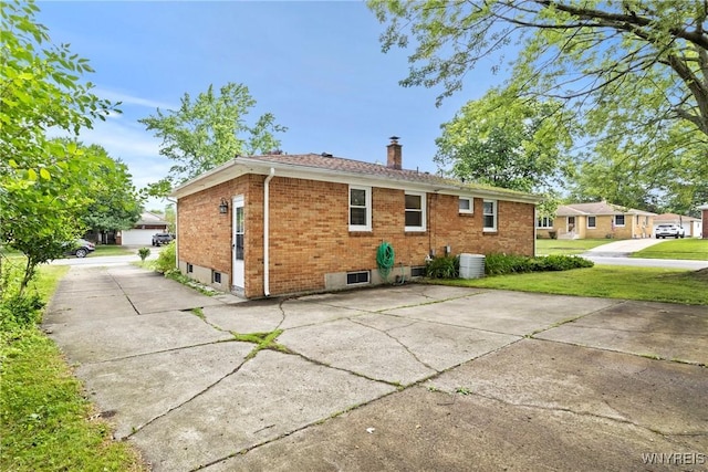 73 Willowcrest Dr, West Seneca, NY 14224 - back of property featuring brick siding, a chimney, and a yard