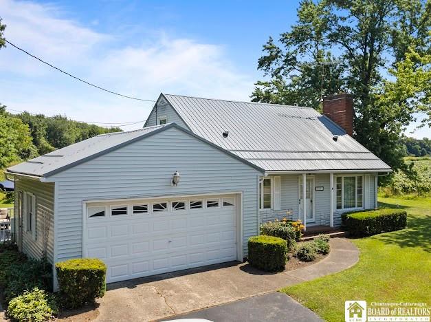 5005 W Main Rd, Pomfret, NY 14063 - view of front of home featuring a front yard, a chimney, a metal roof, covered porch, and an attached garage