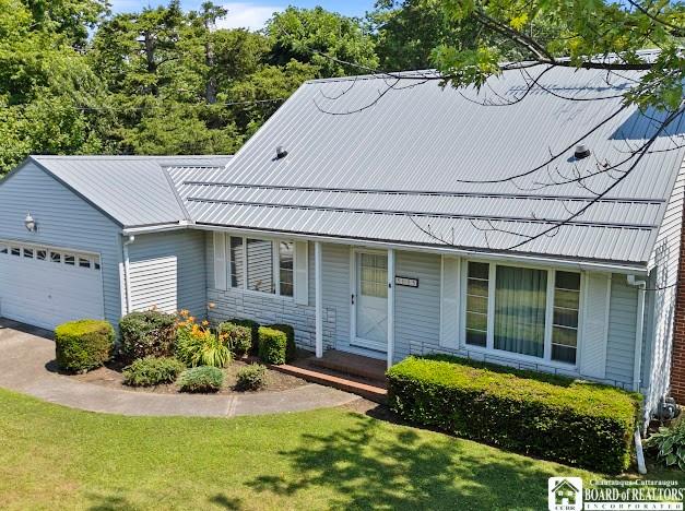 5005 W Main Rd, Pomfret, NY 14063 - view of front of house featuring a garage, a front lawn, and a metal roof
