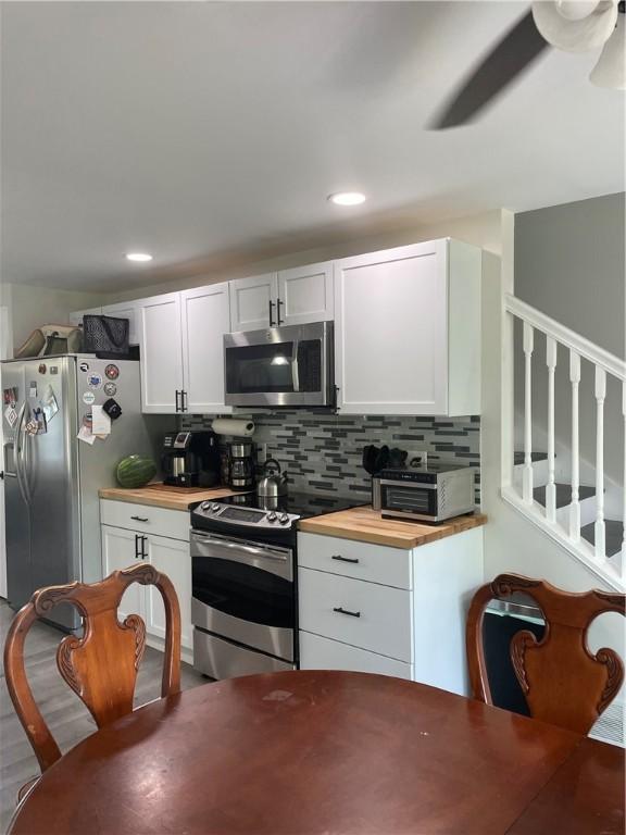 16562 Ridge Rd, Murray, NY 14470 - kitchen featuring stainless steel appliances, butcher block countertops, white cabinets, tasteful backsplash, and recessed lighting