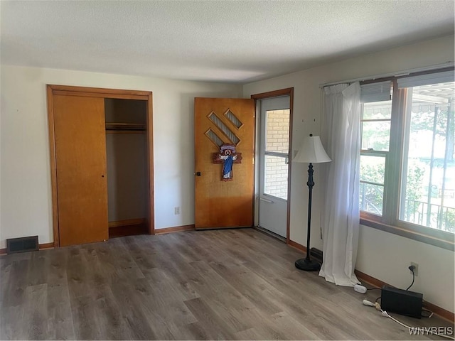 275 Nagel Dr, Cheektowaga, NY 14225 - unfurnished bedroom with wood finished floors, a closet, and a textured ceiling