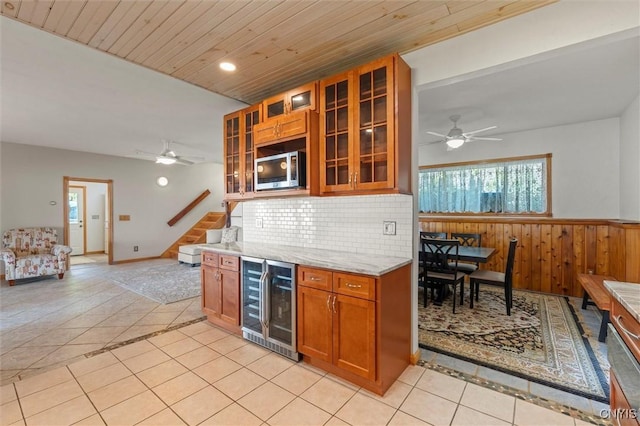 1659 Honoco Rd, Ledyard, NY 13026 - kitchen with wine cooler, stainless steel microwave, light tile patterned floors, wooden ceiling, and a wainscoted wall